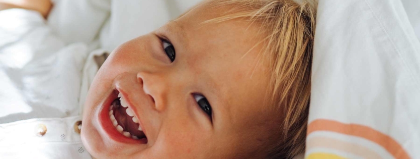 Niño rubio sonriendo a camara con dientes de leche