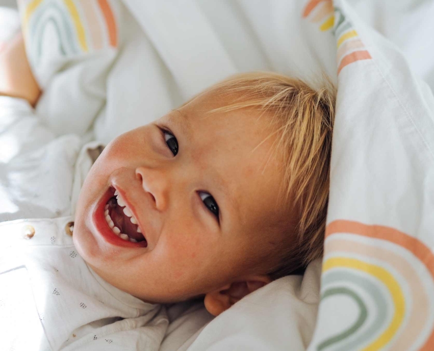 Niño rubio sonriendo a camara con dientes de leche