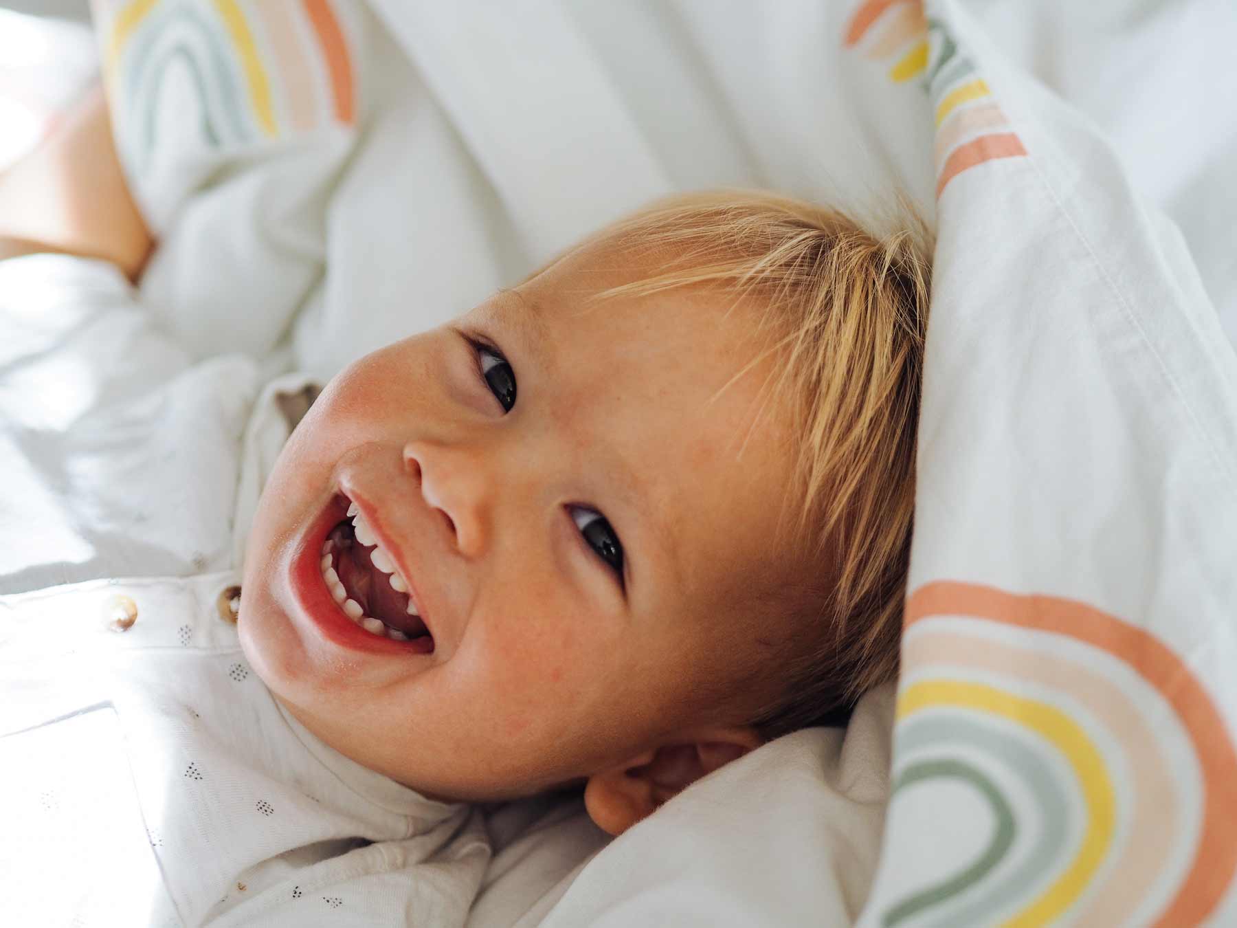 Niño rubio sonriendo a camara con dientes de leche