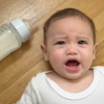 Bebé con síndrome del biberón tumbado en suelo