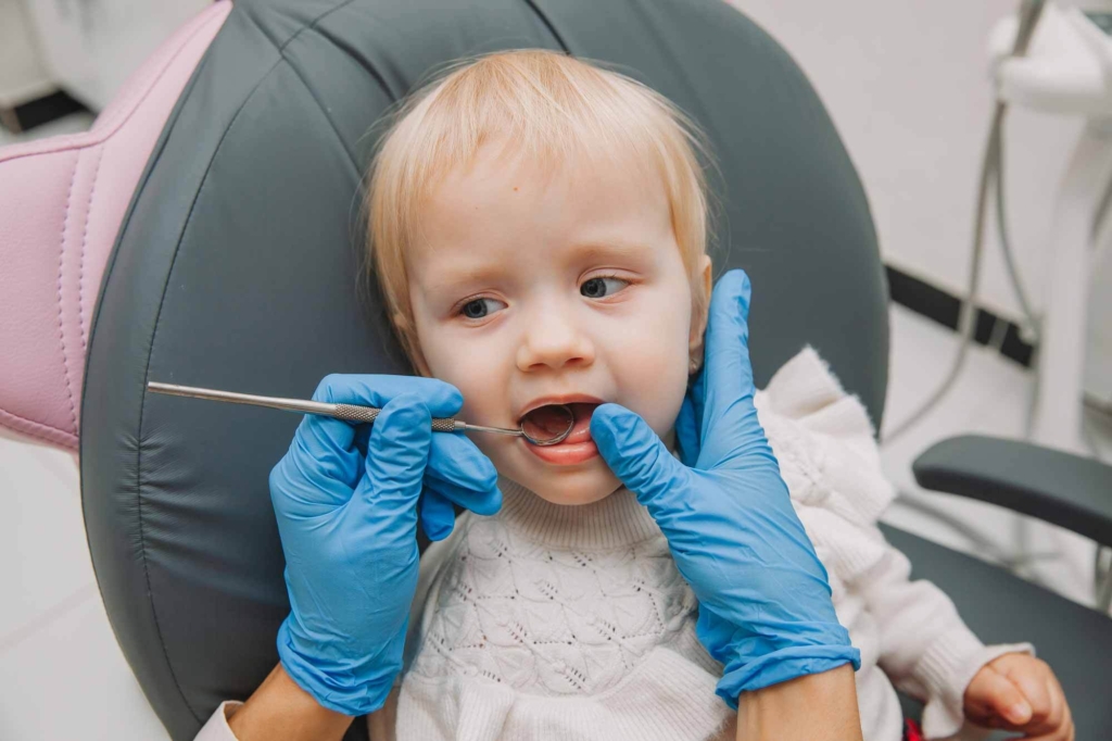 Bebé en consulta con dentista sentado en silla