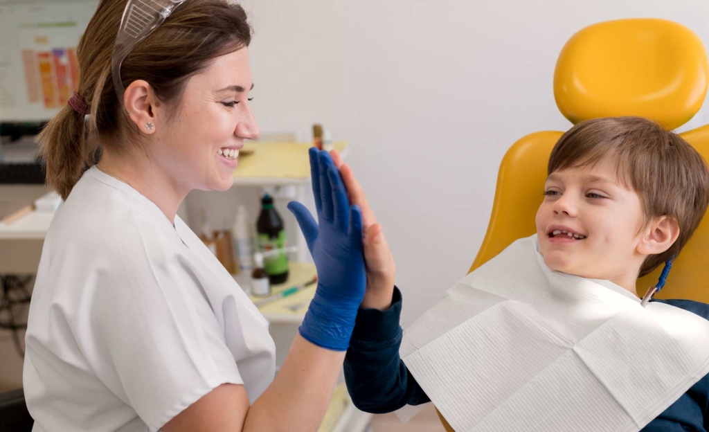 Niño en la consulta del dentista feliz