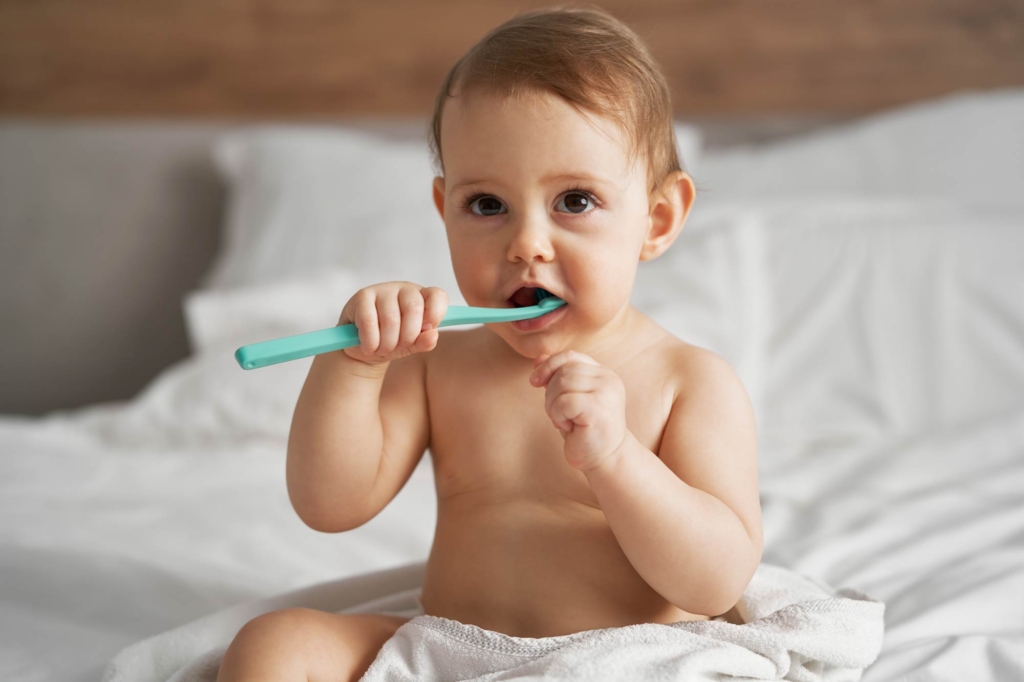 bebe con un cepillo de dientes en la cama