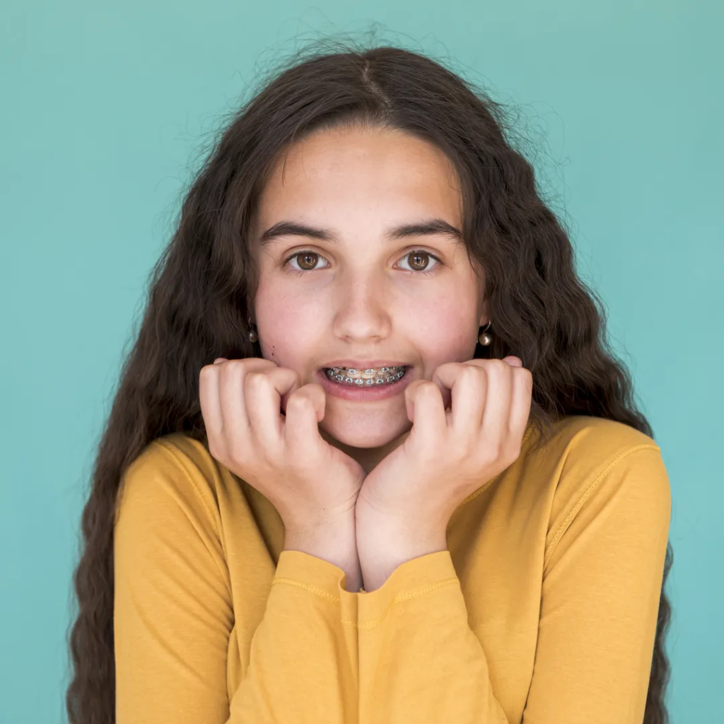 niña sonriente con brackets puestos