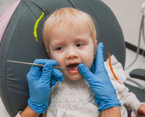 Bebé en la silla del dentista mientras el revisan los dientes