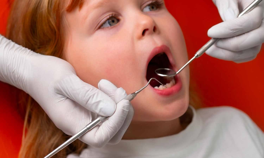 niño en consulta del dentista realizando revisión de los dientes